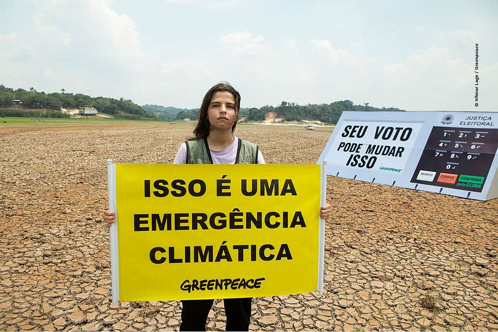 Ativistas do Greenpeace levaram uma réplica de urna eletrônica de 5 metros de comprimento para o Lago do Aleixo, em Manaus, Amazonas, completamente seco devido à estiagem. A mensagem "seu voto pode mudar isso" destaca a urgência de escolher candidaturas comprometidas com propostas de adaptação das cidades e apoio às comunidades afetadas pela estiagem, garantindo acesso a água, alimentação, saúde e educação.