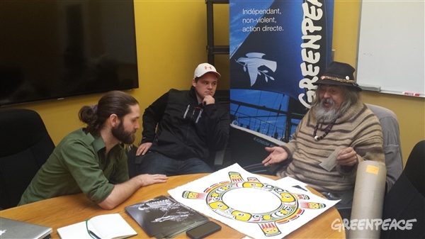 Kwakwaka'wakw artist Beau Dick revealing his new Sisiutl symbol at the Greenpeace Vancouver office (to his left is Cole Speck who applied the colours and Mark Worthing who was the researcher the project) Photo: Eduardo Sousa 