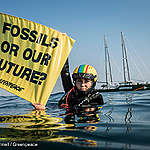 Danish activist with hand banner reading "Fossils our our future"