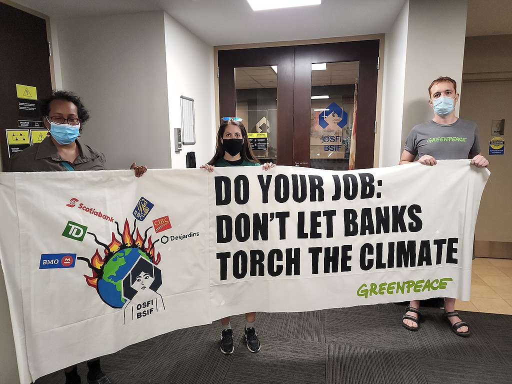 Greenpeace activists deliver a message to Canada's banking regulator: Don't let banks torch the climate
