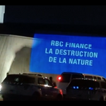 Projection en pleine soirée qui dit "RBC finance la destruction de la nature"