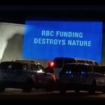 Night projection saying "RBC Funding Destroys Nature"