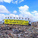 Greenpeace Africa volunteers with a banner reading "Cut Plastics by 75% to keep planet alive", at the heart of the Dandora dumpsite. As vast stretches of land are swallowed by discarded plastics, it underscores the urgency of our call: a reduction in plastic production by 75%.