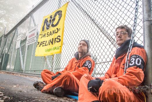 Two Greenpeace activists chained to front gate of Transmountain pipeline terminal in suburban Vancouver in 2013.