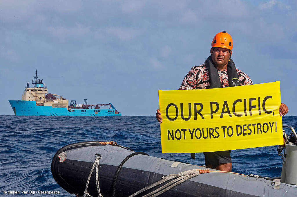 Victor Pickering, a Greenpeace International activist from Fiji  displays a banner reading “Our Pacific Is Not Yours To Destroy” in front of the Maersk Launcher, a ship chartered by DeepGreen, one of the companies spearheading the drive to mine the barely understood deep sea ecosystem. The Rainbow Warrior is in the Clarion Clipperton Zone in the Pacific to bear witness to the  deep sea mining industry. Part of the ongoing 'Protect the Oceans' campaign.