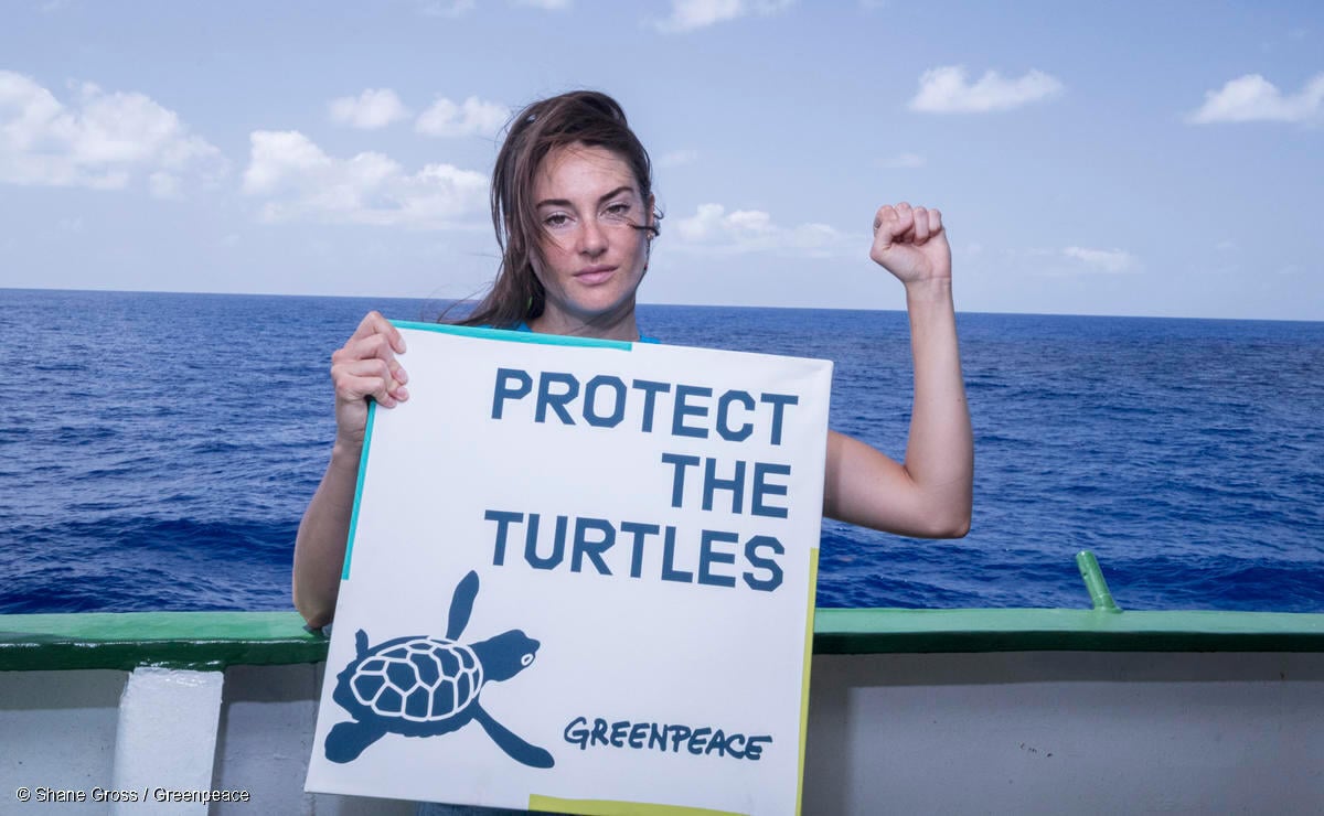 La actriz y activista Shailene Woodley, sostiene un cartel de Greenpeace que dice "Protejamos a las tortugas".