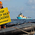 Victor, a Greenpeace International  activist from Fiji displays a banner reading “Stop Deep Sea Mining” in front of the Maersk Launcher, a ship chartered by DeepGreen, one of the companies spearheading the drive to mine the barely understood deep sea ecosystem.

The Rainbow Warrior is in the Clarion Clipperton Zone in the Pacific to bear witness to  deep sea mining industry.