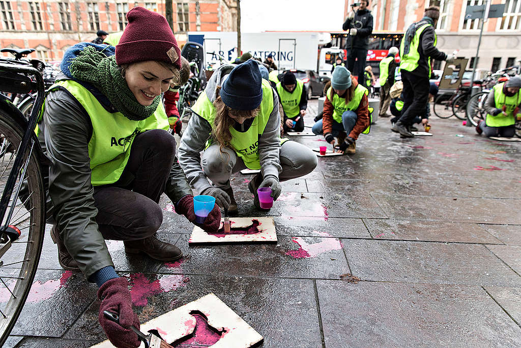 Kreativ aktion: Greenpeace forsøger at tegne tusind døde pattegrise foran Miljø- og Fødevareministeriet. © Andreas Bro