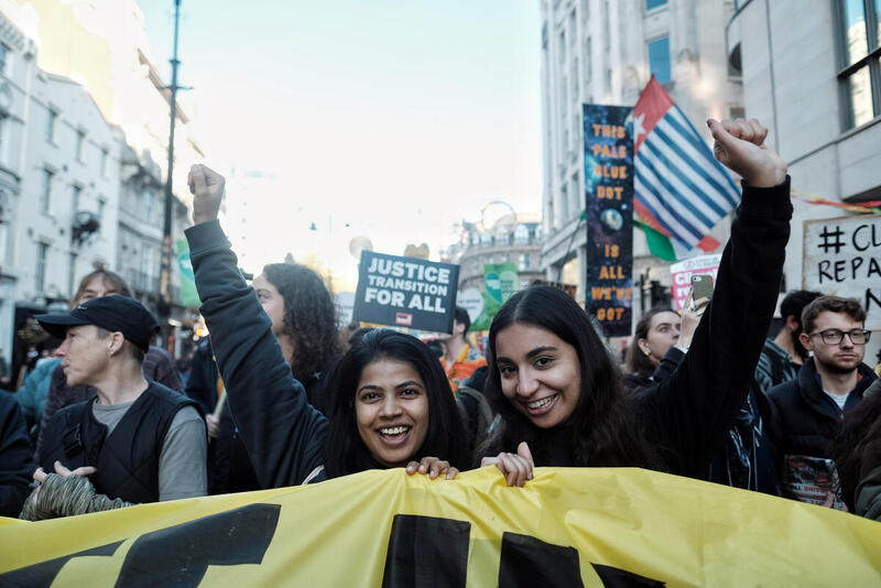 To kvinder holder banner til klimaprotest i London