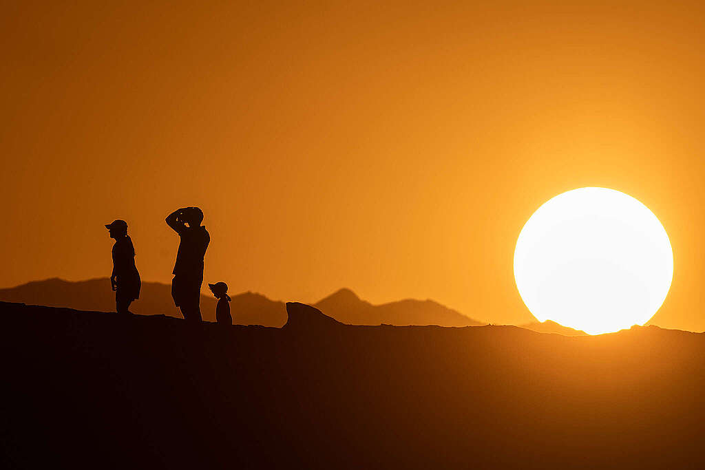 People are silhouetted before the setting sun in Death Valley National Park.
