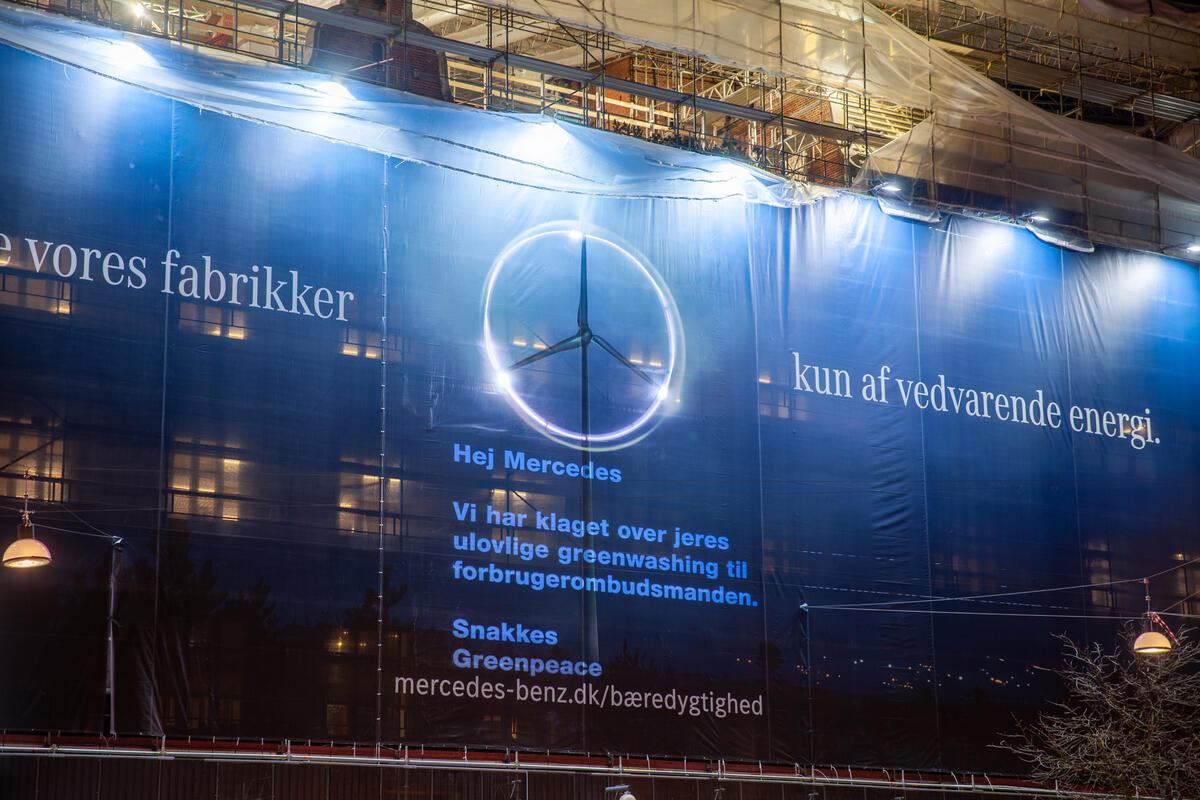 Greenpeace indgav en klage til Forbrugerombudsmanden over en greenwashing-annonce fra Mercedes-Benz. Ved indgivelsen af ​​klagen gennemførte aktivister en protest på Rådhuspladsen, hvor Mercedes-Benz’ gigantiske annonce fik en besked påført med en projektor. © Michael Hedelain / Greenpeace