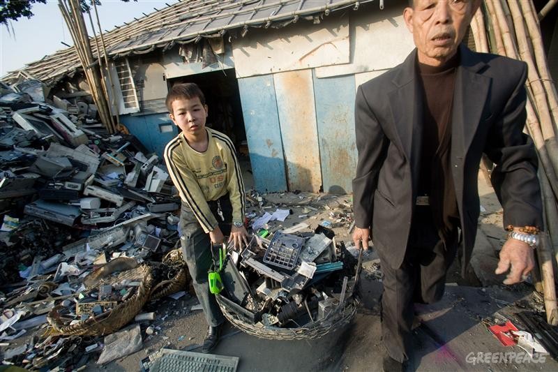Chinese workers surrounded by e-waste