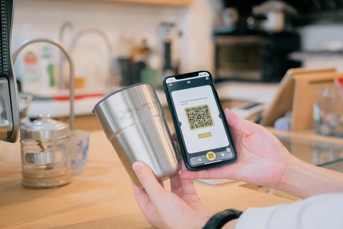 Show the QR code in your mobile app at the participating coffee shop in Sheung Wan, and your takeaway drink will be served in a reusable cup. © Chilam Wong / Greenpeace