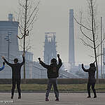 Local middle-aged women dance together with their backs to the Handan Stadium facing the Wen'an steel plants. These women come here every day at the same time. Wu'an is home to dozens of steel mills, power stations, and coking plants. Whatever the wind direction, the pollution is always choking. Air pollution has become one of the most severe environmental problems in mainland China.