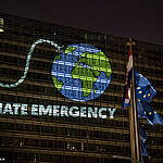 Greenpeace activists in Brussels project an image of the Earth as a bomb with a lit fuse onto European Commission headquarters ahead of an EU summit on EU's top jobs, five-year plan, and response to climate change. The message reads in various languages: Climate Emergency – Time's Running Out – EU Act Now.