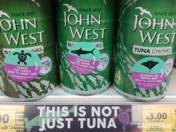 Aktivistien tarroittamia tonnikalasäilykkeitä.
