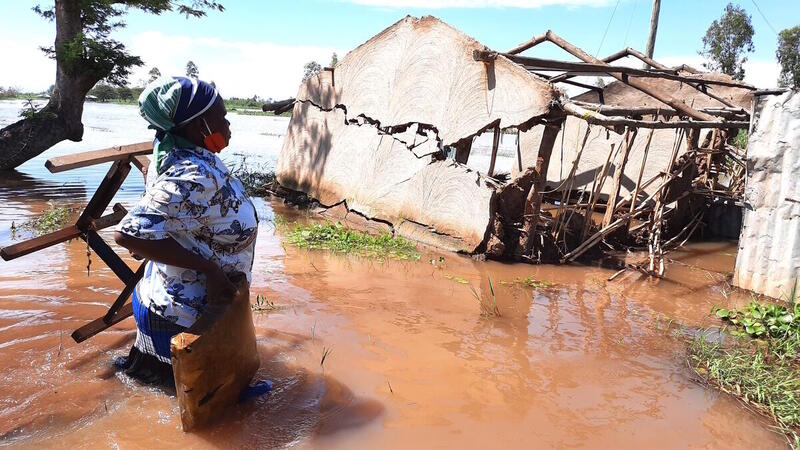 Nainen katsoo tulvan tuhoamaa taloaan Keniassa.