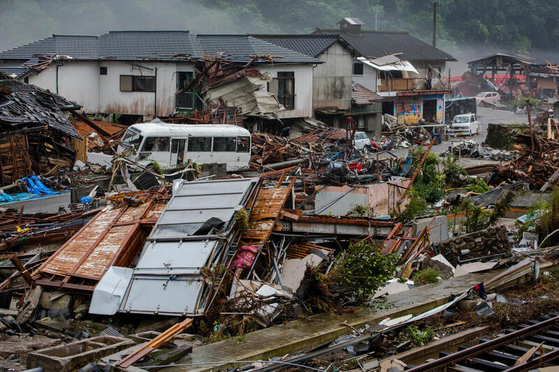 Tuhoja Hitoyoshissa, Japanissa. Taloja on sortunut ja autoja on hajonnut.