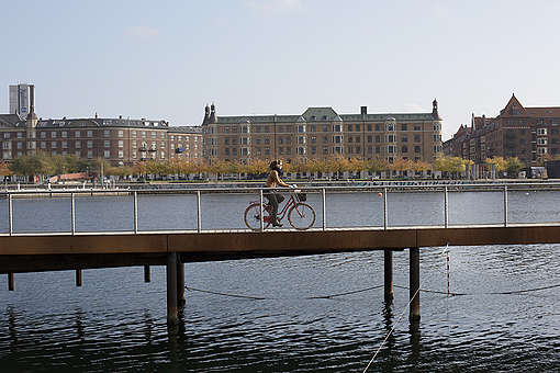 Pyöräijä pyöräilee sillan yli.