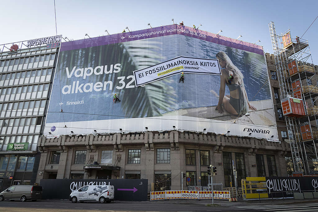 Greenpeacen aktivistit kiinnittivät oman banderollinsa Finnairin mainoksen päälle. Finnairin mainosessa lukee "Vapaus alkaen 32€" Greenpeacen banderollissa on teksti "Ei fossiilimainoksia, kiitos".