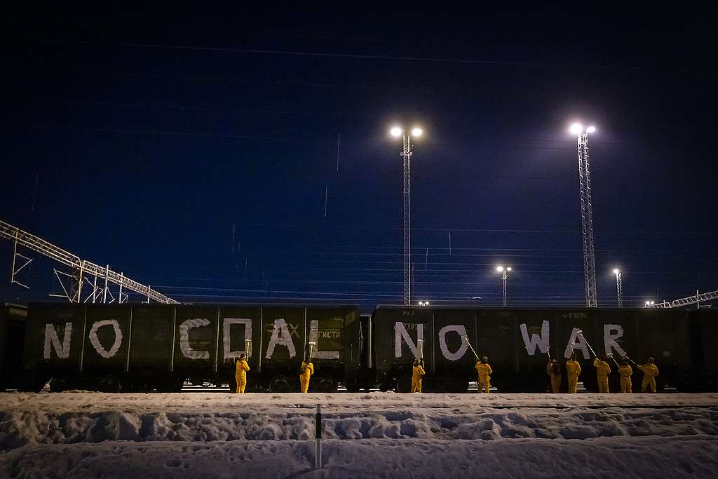 Aktivistit maalaamassa hiilijunan vaunuihin tekstiä "NO COAL NO WAR".
