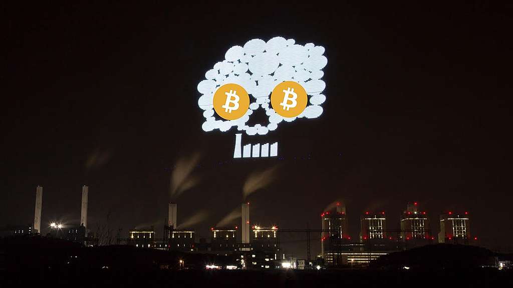 Rakennuksen seinään heijastettu pääkallon kuva, jonka silminä ovat Bitcoinin symbolit.