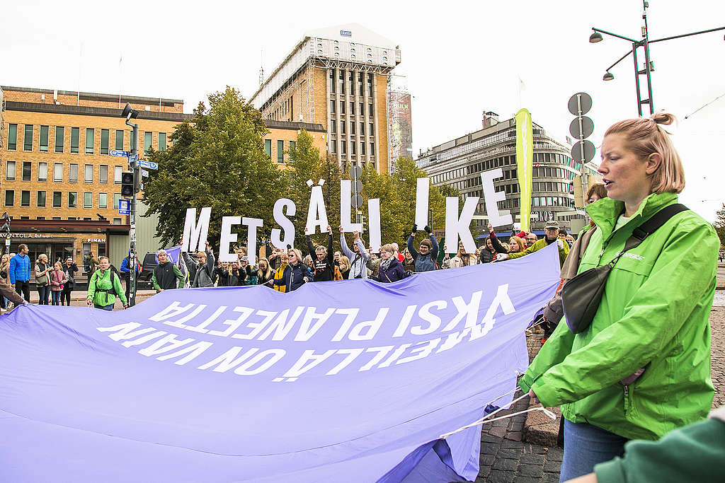 Mielenosoittajia metsämarssilla banderollin ympärillä, jossa lukee "Meillä on vain yksi planeetta". Takarivissä ihmisillä on kädessä kirjaimia, jotka muodostavat sanan "metsäliike." 