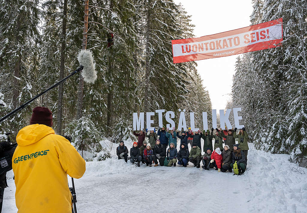 Metsäliike osoittamassa mieltä Lapinjärvellä. Taustalla näkyy puihin kiinnitetty banderolli, jossa teksti "LUONTOKATO SEIS".