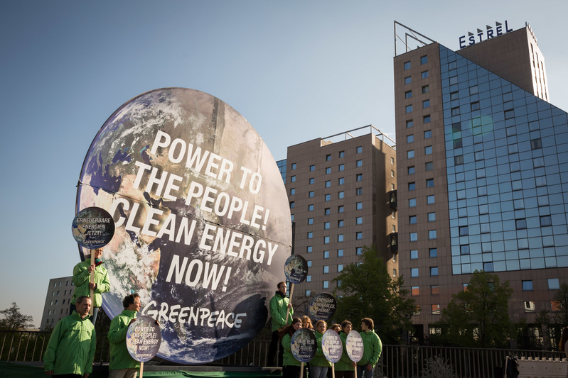 Mielenosoitus IPCC:n konferenssissa Berliinissä. Kuvan keskiössä on maapallon muotoinen kyltti, jossa teksti "Power to the people! Clean energy now!".