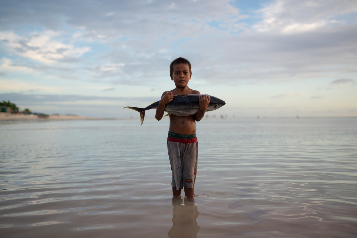 Boy with Tuna Fish Stands in Sea. © Christian Åslund / Greenpeace Boy with Tuna Fish Stands in Sea. © Christian Åslund / Greenpeace