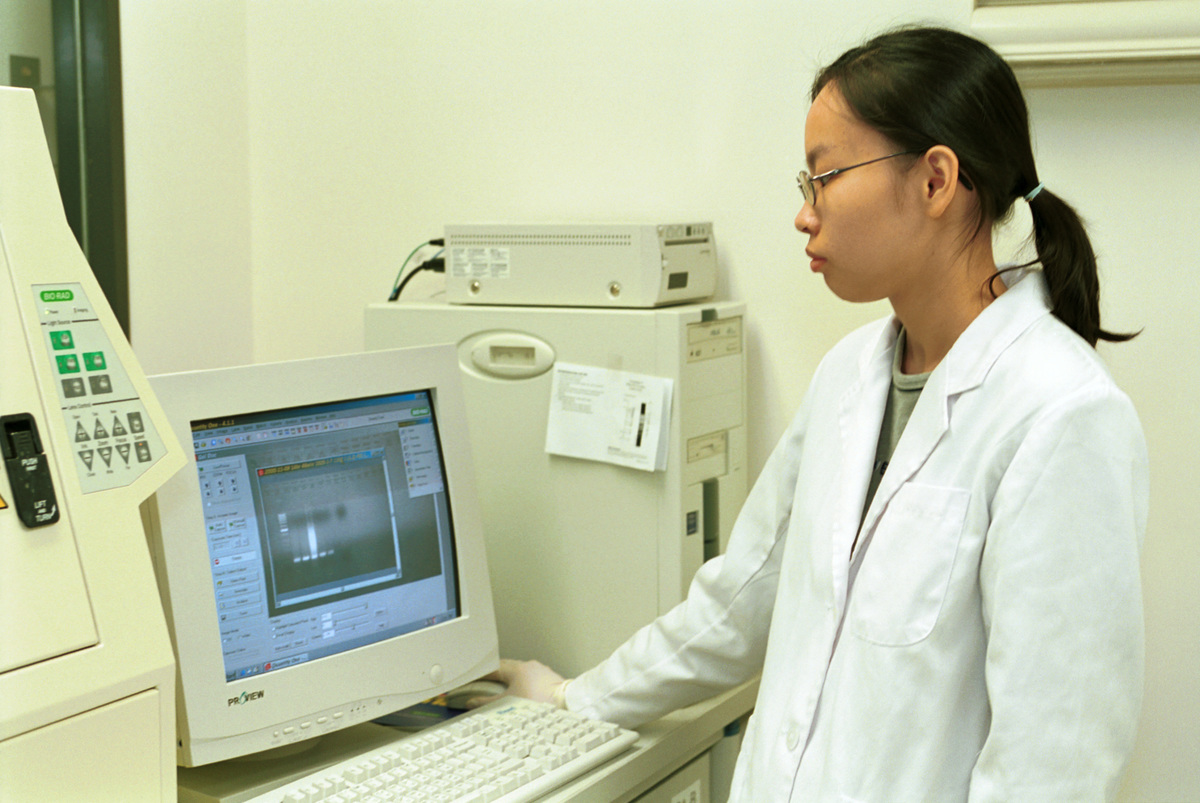 Staff analyzing PCR data by UV trans-illuminator and gel documentation system in the GE sampling lab DNA Chips Ltd, Hong Kong, China. © Greenpeace / Cheung Chi Yun
