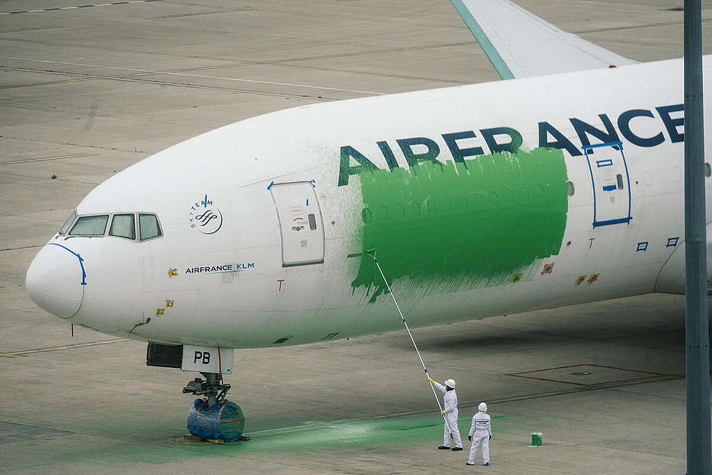 Activists Paint a Plane Green in Action against Greenwashing in Paris Airport. © Denis Meyer / Greenpeace