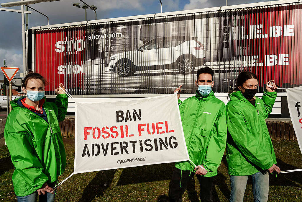 Busting Fossil Car Ad in Brussels. © Eric De Mildt / Greenpeace