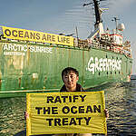 A Greenpeace crew member holds a banner reading 'Ratify The Ocean Treaty' from a RHIB in the Pacific Ocean. The Greenpeace ship Arctic Sunrise is seen in the background with a banner that reads 'Oceans Are Life'.

The Arctic Sunrise is on a six-week expedition around the Galápagos islands, with scientists from the Jocotoco Conservation Foundation, the Charles Darwin Foundation, the Galápagos Science Center, MigraMar and Galápagos park rangers. The expedition will showcase the power of marine protection by documenting the success of the Galápagos Marine Reserve through the incredible wildlife and habitats of the sea near the Galápagos. Data collected during the expedition will help to make the case for a new high seas protected area.
