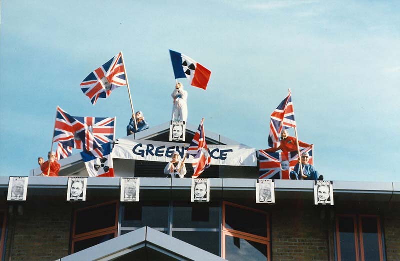 21 November 1995: Greenpeace activists protest against the 4th French nuclear weapon test of the year by climbing onto and occupying the roof of the British High Commission in downtown Wellington. Wearing John Major and Jacques Chirac masks and waving ‘Union Jacques’ flags, they set-off loud sirens to draw attention to the British Government’s support for the French Government’s nuclear weapons testing programme. Photo: Rob Taylor 