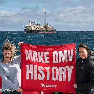 Greenpeace Climate Campaigner Amanda Larsson and Greenpeace activist Sophie Schröder hold banner reading "MAKE OMV HISTORY" in front of OMV-owned oil processing ship.