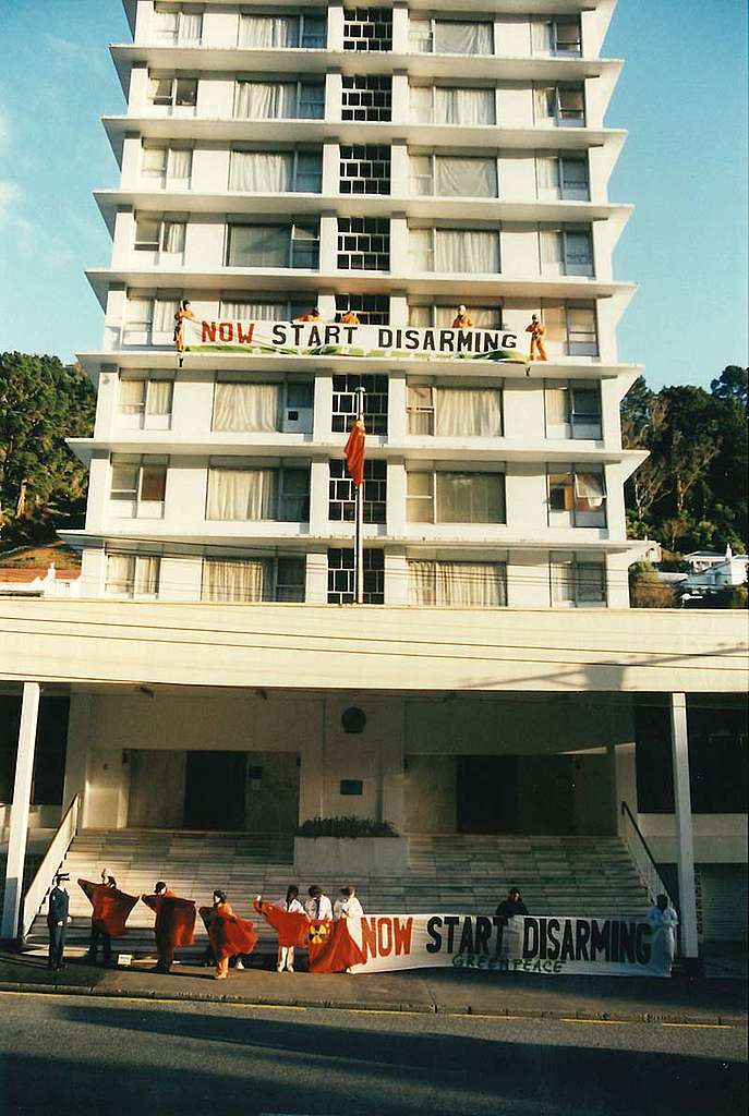 30 July 1996: Greenpeace activists scale the Chinese Embassy in Wellington to hang a banner after the Chinese Government’s 45th – and last ever – nuclear weapons test at remote Lop Nor in Xin Jiang Province. The 4th-floor banner read “Now Start Disarming” and a ‘Rad’ flag was run up the embassy’s flag pole while more activists held up a second “Now Start Disarming” banner and more ‘Rad’ flags in front of the embassy entrance. Photo: Rob Taylor