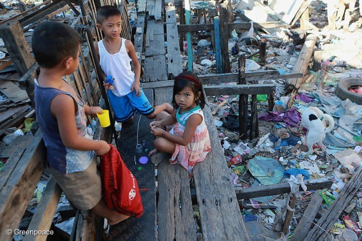 Children play on a trash-filled river in Barangay Bagumbayan North in Navotas City, Philippines.