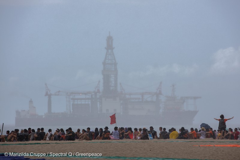 In Copacabana beach, a 100-meter image was formed by more than 500 people. Around 200 of them were students from public schools in Rio de Janeiro. The action was coordinated by the artist John Quigley with Greenpeace Brazil for the Defend The Amazon Reef campaign. The goal is to stop an oil exploration near this recently discovered marine biome.Na praia de Copacabana, uma imagem de 100 metros de comprimento foi formada por mais de 500 pessoas. Cerca de 200 eram estudantes de escolas públicas do Rio de Janeiro. A ação foi coordenada pelo artista John Quigley junto ao Greenpeace Brasil para a campanha Defenda os Corais da Amazônia, que quer barrar a exploração de petróleo perto desse bioma marinho, descoberto há pouco tempo.