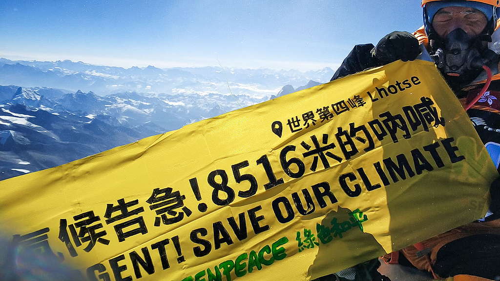 阿建在洛子峰頂拉起橫額,呼籲大眾正視氣候危機。 © Greenpeace