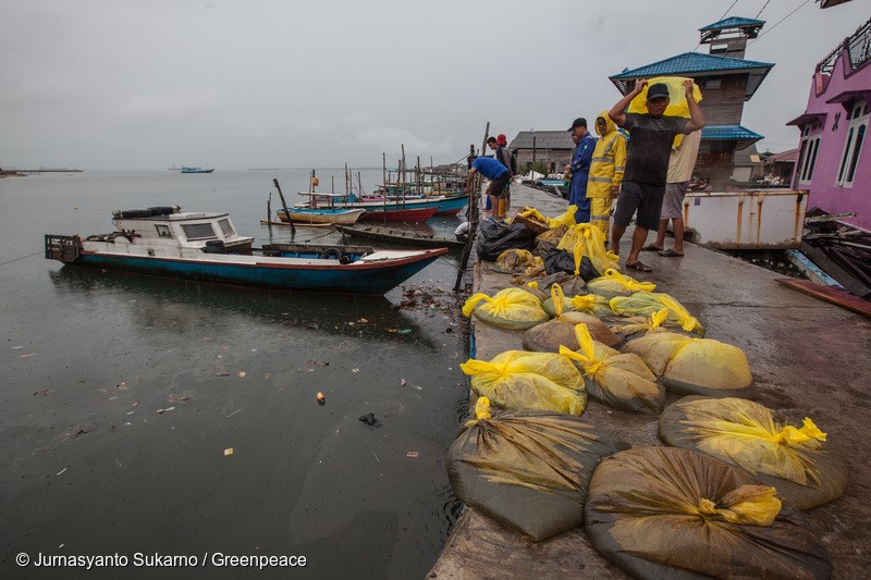 Fishermen collecting plastics contain water and oil next to Pertamina's refinery installation in Margasari village, Balikpapan Bay, East Kalimantan. An oil spill off Balikpapan bay in Borneo island that led to five deaths and the declaration of a state of emergency was caused by a burst of undersea pipe belongs to Indonesia's state oil company Pertamina