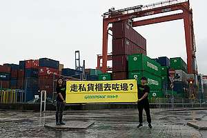綠色和平成員在葵涌貨櫃碼頭前拉起橫額，促請環保署及海關調查涉嫌走私洋垃圾事件© Siu Wai Hang / Greenpeace