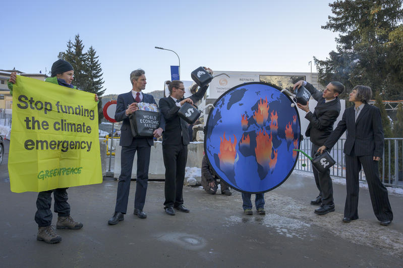 行動者於論壇期間在會場外上演真實戲碼：「銀行家」的投資決定往往以短期利益掛帥，卻等同往火裡澆油，令氣候危機、全球暖化越吹越盛。© Greenpeace / Ex-Press / Flurin Bertschinger