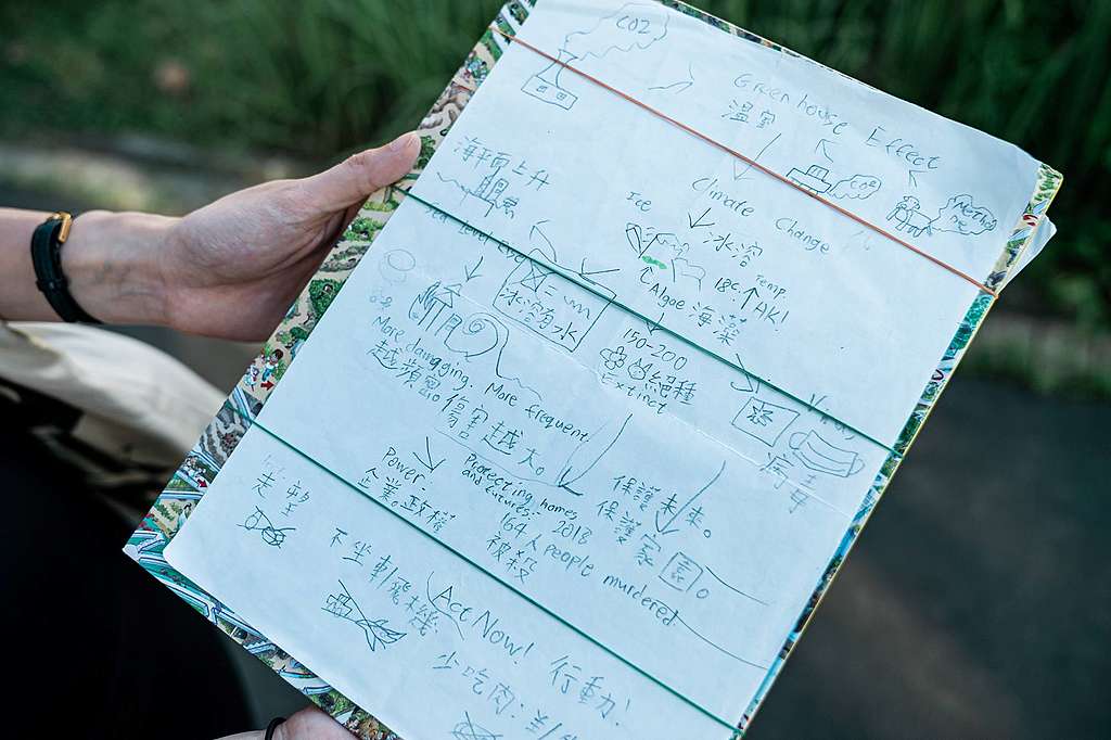 Lance用硬皮圖書、橡筋做成環保文件夾,有聯署書、綠色投書還有他手作的氣候信息圖。© Patrick Cho / Greenpeace