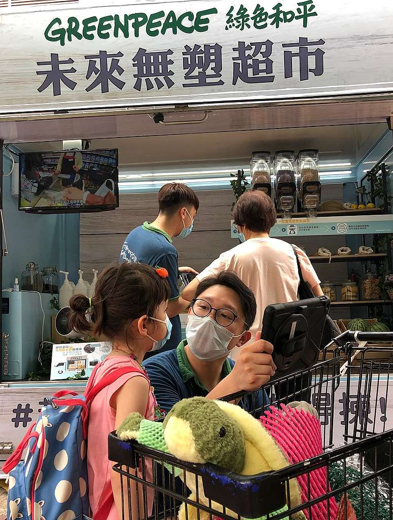 「未來無塑超市 Pop-up 流動店」大埔開店,籌款隊長Skyrus講的走塑故事,小女孩聽得津津有味。© Greenpeace