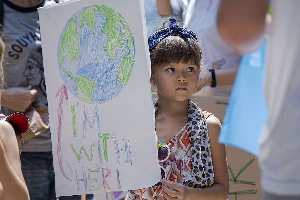 2019 年 3 月的泰國氣候遊行，小女孩舉起「I'm With Her」標語，為地球打氣。 © Biel Calderon / Greenpeace