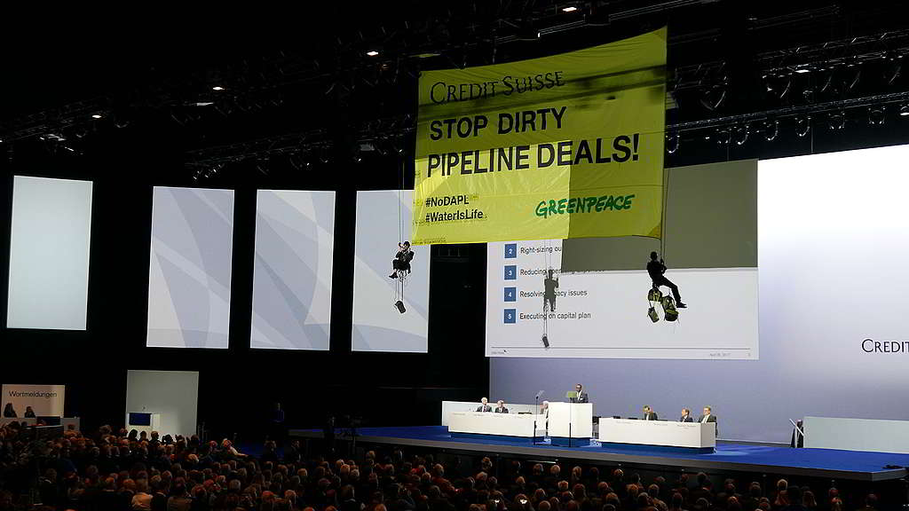 行動者2017年於蘇黎世的瑞信周年大會會場懸掛橫額，要求金融機構撤資油管工程。 © Daniel Grunder / Greenpeace
