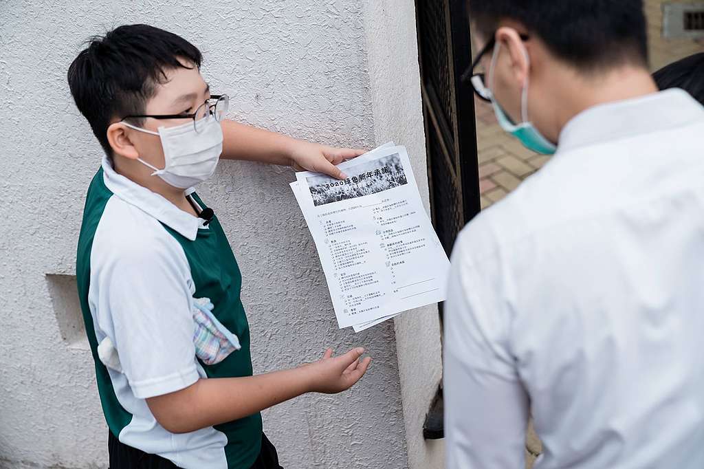 Lance每星期在校門外為氣候行動，與人分享他對環境改進的願景。© Patrick Cho/Greenpeace