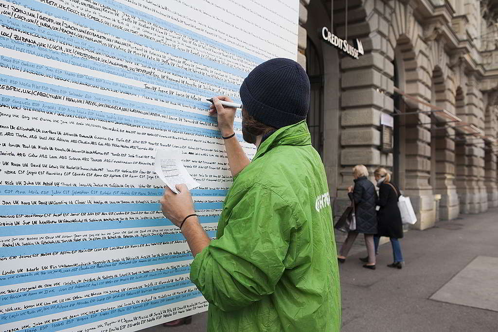 行動者逐個抄寫40,000位聯署者的名字，展現反對油管工程的群眾力量。© Miriam Künzli / Greenpeace