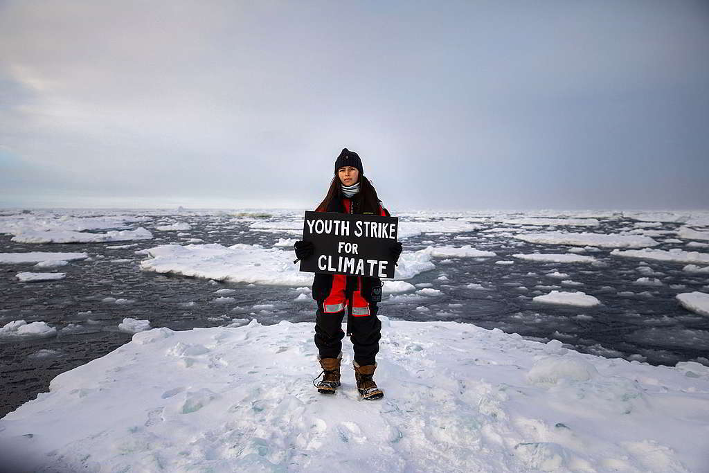Mya-Rose舉起「年輕人為氣候行動」標語，完成歷來地球最北端的氣候行動。 © Daniella Zalcman / Greenpeace
